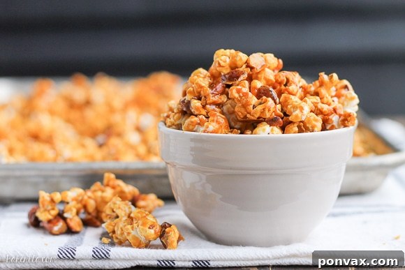 Freshly coated Salted Honey Almond Caramel Corn spread on baking sheets.