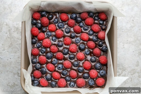 These Chocolate Berry Bars have an almond flour crust topped with vegan chocolate ganache and fresh raspberries and blueberries. These dessert bars are beautiful, delicious, and better for you - they're gluten-free, vegan, refined sugar-free, and Paleo.