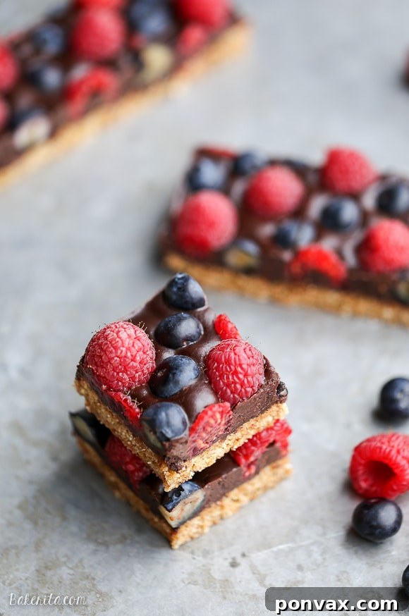 These Chocolate Berry Bars have an almond flour crust topped with vegan chocolate ganache and fresh raspberries and blueberries. These dessert bars are beautiful, delicious, and better for you - they're gluten-free, vegan, refined sugar-free, and Paleo.