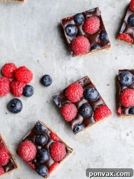 These Chocolate Berry Bars have an almond flour crust topped with vegan chocolate ganache and fresh raspberries and blueberries. These dessert bars are beautiful, delicious, and better for you - they're gluten-free, vegan, refined sugar-free, and Paleo.