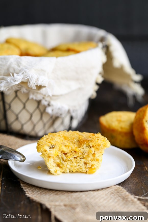 A close-up of a warm, freshly baked Green Chile Corn Muffin, showcasing its moist interior and savory ingredients.
