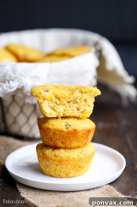 A rustic plate filled with several Green Chile Corn Muffins, showcasing their inviting golden crust and cheesy texture.