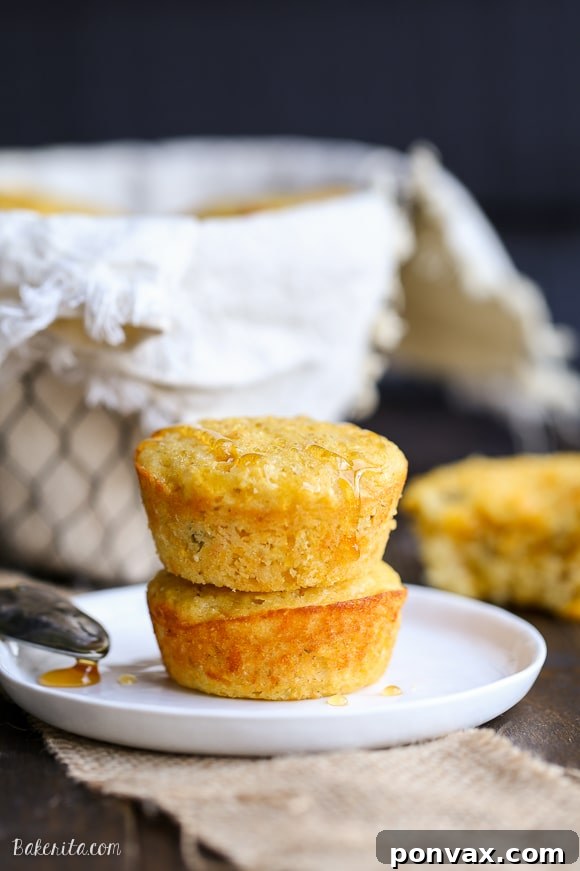 A single Green Chile Corn Muffin artfully placed on a wooden surface, highlighting its appetizing details and fresh bake.