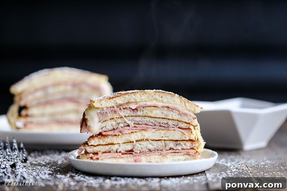 Close-up of a Monte Cristo Pancake stack revealing ham, cheese, and jam filling