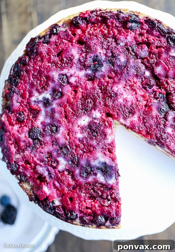 The full Berry Upside Down Cake, freshly inverted and cooled, presenting a stunning mosaic of colorful berries and a tender golden cake, ready to be sliced and enjoyed.