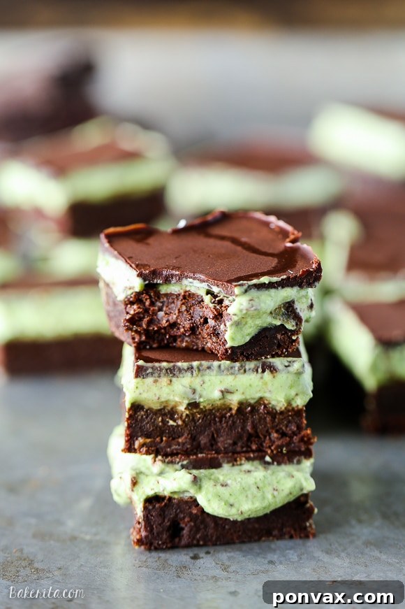A slice of Mint Chocolate Chip Brownie placed on a light surface, highlighting the thick, rich brownie layer beneath the bright mint and chocolate topping.