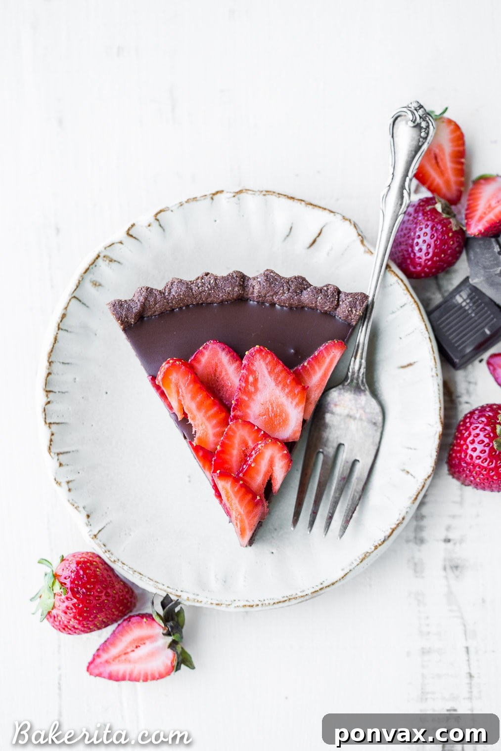 This Strawberry Chocolate Tart is filled with vegan chocolate ganache and topped with fresh strawberries, all in a chocolate crust. Slice into this easy and delicious gluten-free, Paleo, and vegan dessert.