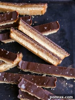 Homemade Paleo Twix Bars, showcasing the three delicious layers of cookie, caramel, and chocolate.