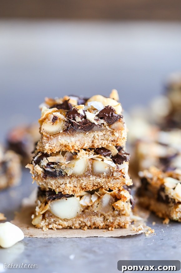 Decadent Dark Chocolate Macadamia Nut Bars Gluten Free Vegan 4 Stack of Dark Chocolate Macadamia Nut Magic Bars showcasing their chewy, layered texture and beautiful golden crust.