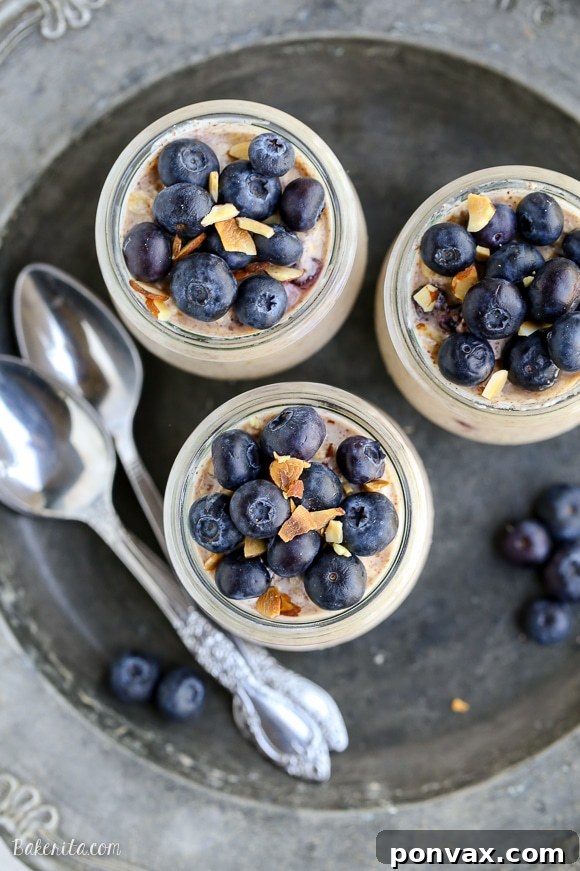 Blueberry Muffin Overnight Delight 4 Three jars of Blueberry Muffin Overnight Oats, garnished with fresh blueberries and almonds.