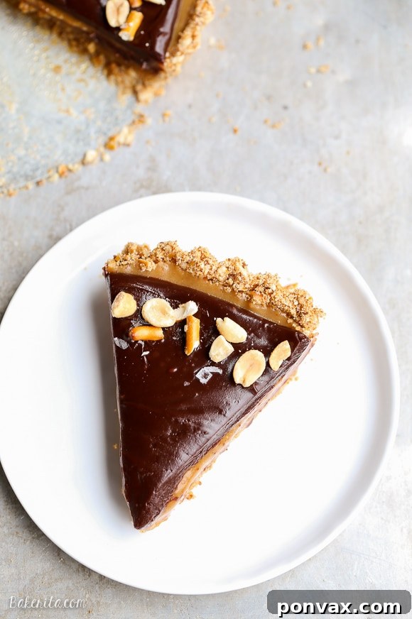 Close-up of the smooth peanut butter caramel filling inside the pretzel crust, ready for the chocolate ganache layer. The tart is gluten-free and vegan.