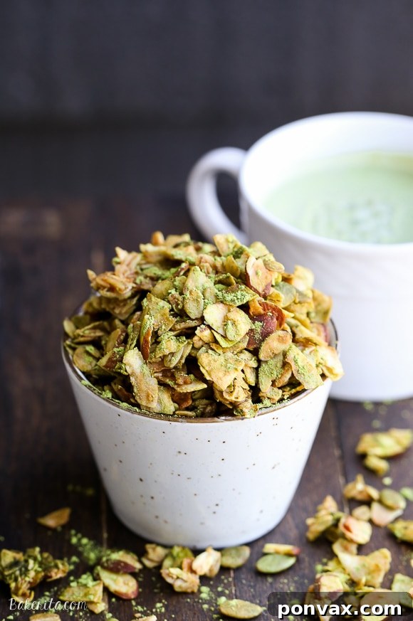 Zen Matcha Granola 5 A hand reaching for a cluster of freshly baked Matcha Granola, emphasizing its irresistible appeal.