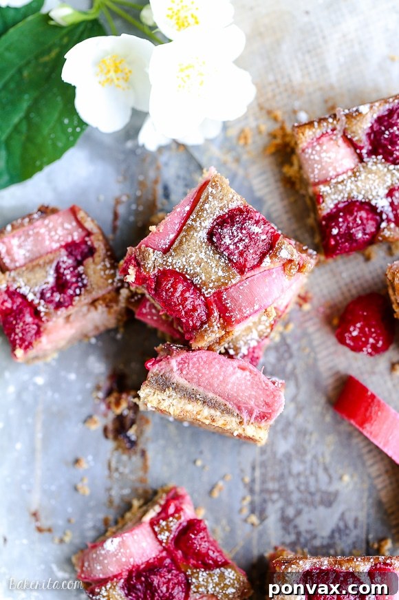 These Raspberry Rhubarb Almond Bars have an crisp almond flour crust topped with soft almond frangipane, fresh raspberries, and tart rhubarb. This recipe is Paleo, gluten free + refined sugar free.