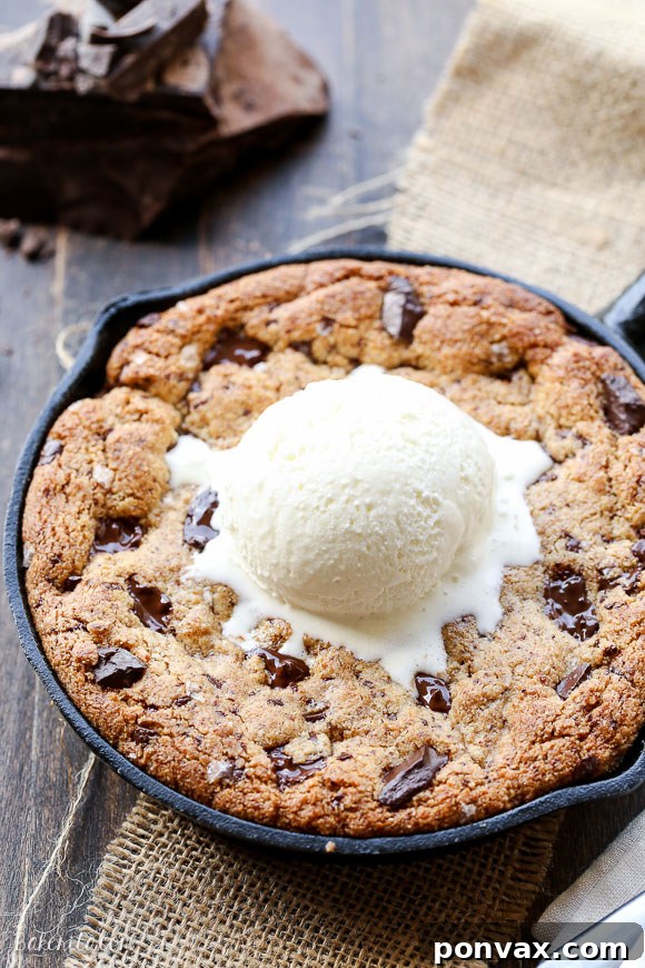 Warm Paleo Skillet Chocolate Chip Dream 4 A Paleo Chocolate Chip Skillet Cookie served in a small cast iron skillet, topped with a scoop of dairy-free ice cream, ready to be enjoyed.