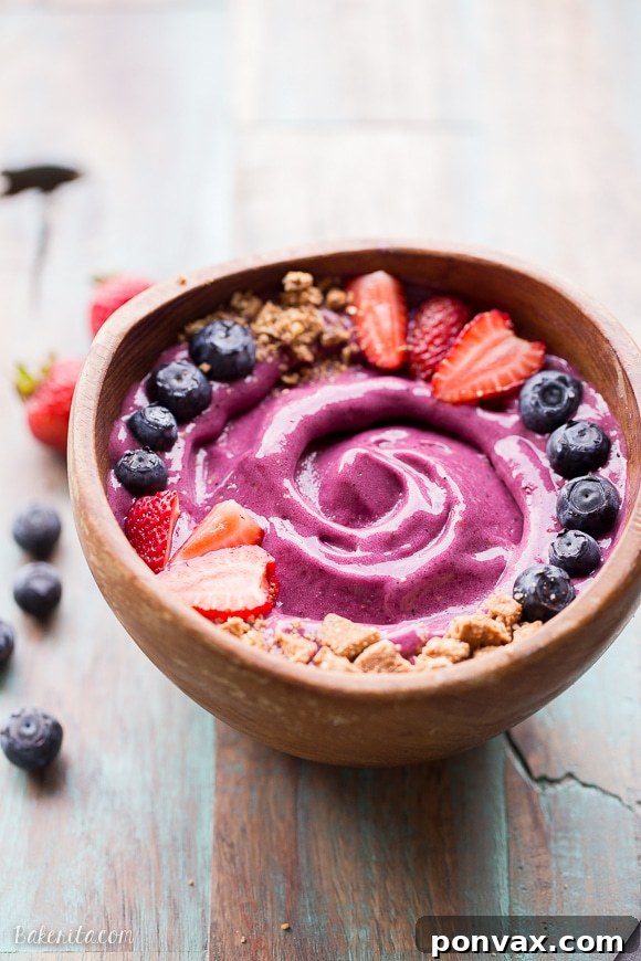 A vibrant Berry Pitaya Smoothie Bowl topped with fresh berries and seeds, showcasing its beautiful fuchsia color.