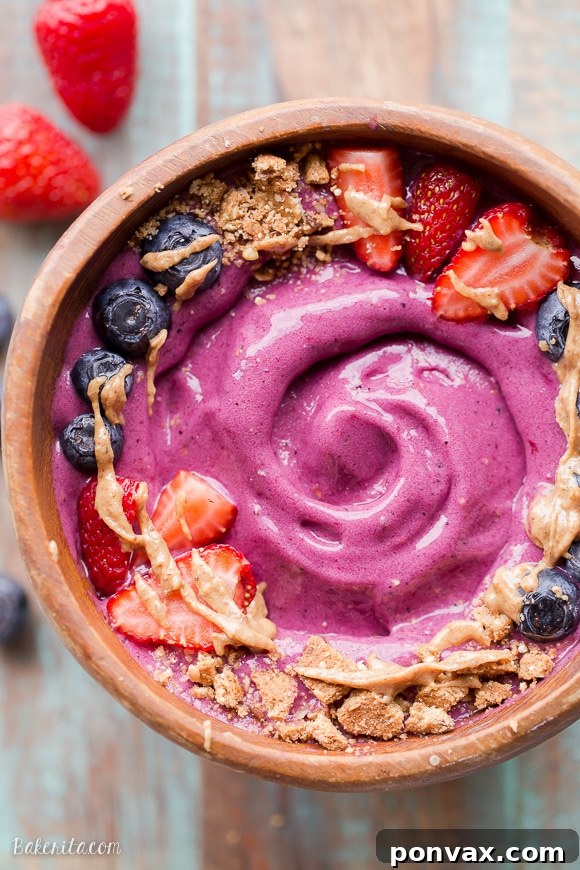 Overhead shot of Berry Pitaya Smoothie Bowl with decorative fruit and seeds.