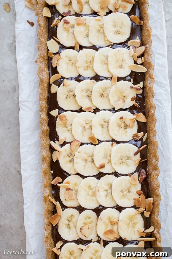 This No-Bake Chocolate Banana Tart has an easy date crust, filled with creamy chocolate ganache and sliced bananas! This quick and simple recipe is only has five ingredients and it's gluten-free, Paleo and vegan.