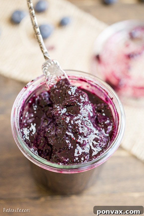 The process of making blueberry chia jam in a saucepan, showing the blueberries breaking down and thickening.