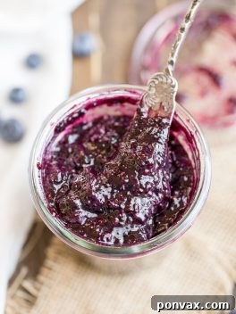 A top-down view of a glass jar filled with fresh homemade blueberry chia jam, ready to be served.