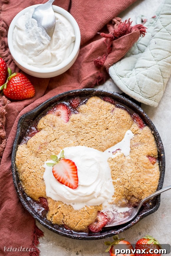 Allergy-Friendly Strawberry Cobbler Dream 5 A serving of strawberry cobbler topped with whipped coconut cream and a spoon.