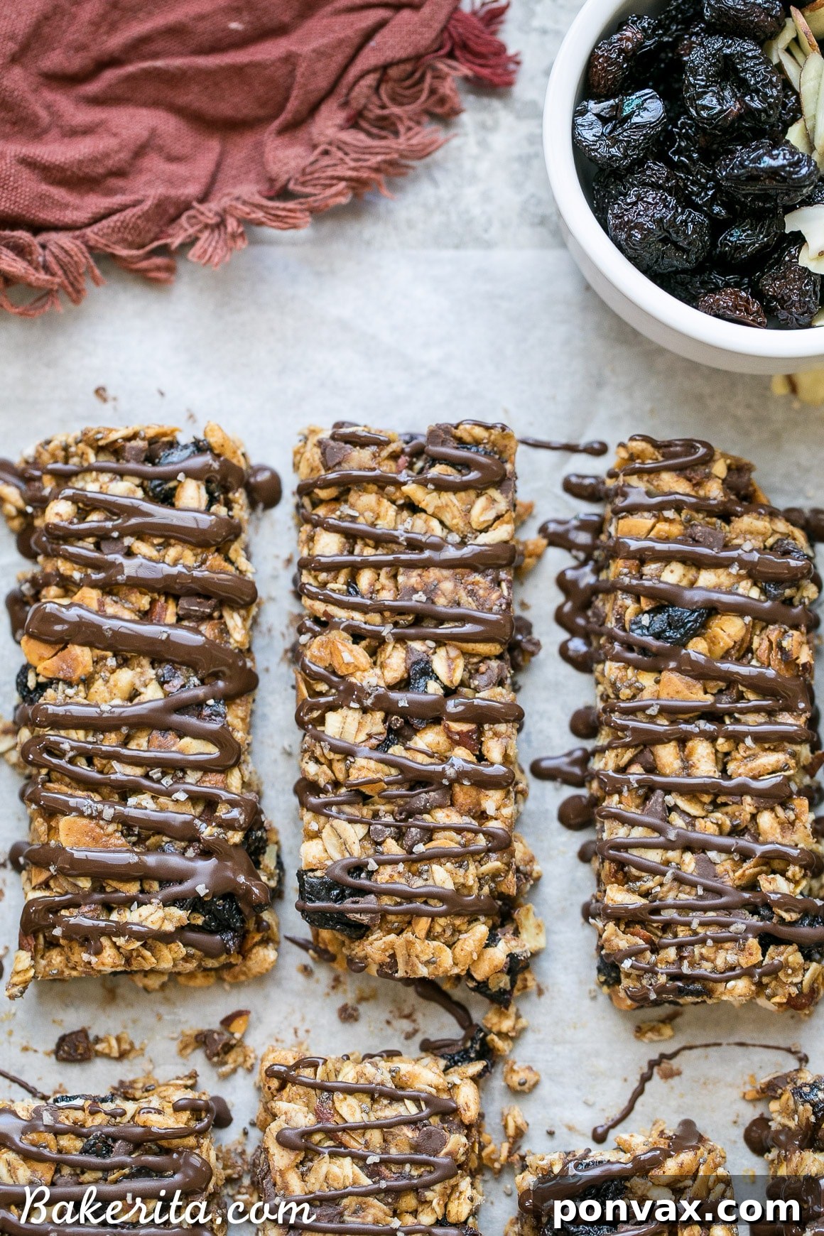 These no bake Dried Cherry, Almond + Chocolate Chip Granola Bars are the perfect grab and go breakfast or snack. These flavor-packed granola bars are gluten free, refined sugar free, vegan, and topped with a dark chocolate drizzle!