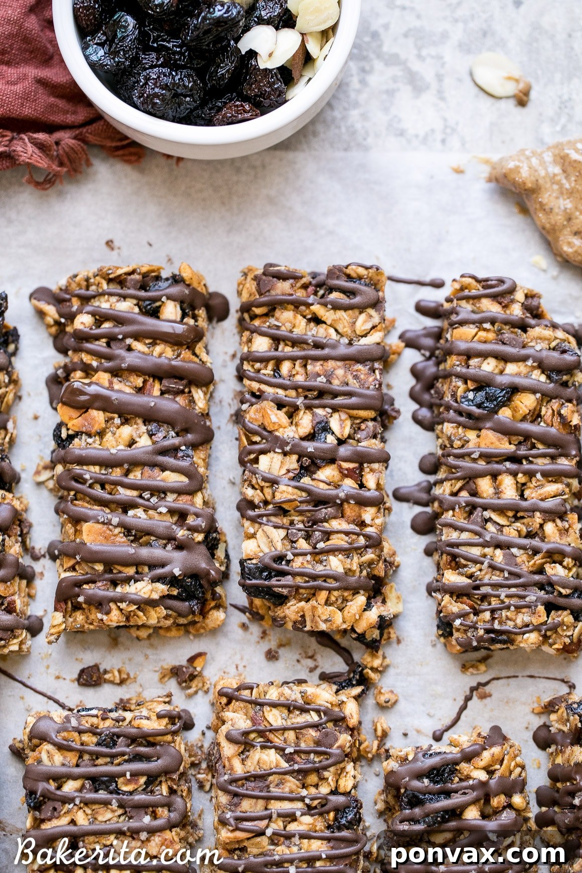 These no bake Dried Cherry, Almond + Chocolate Chip Granola Bars are the perfect grab and go breakfast or snack. These flavor-packed granola bars are gluten free, refined sugar free, vegan, and topped with a dark chocolate drizzle!