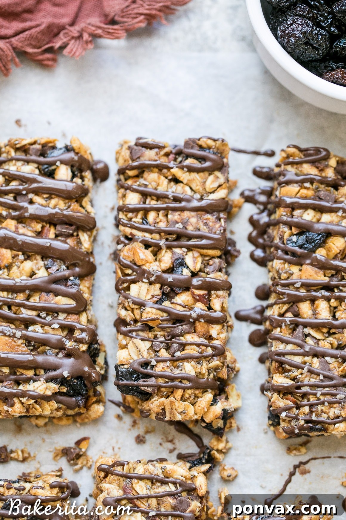 These no bake Dried Cherry, Almond + Chocolate Chip Granola Bars are the perfect grab and go breakfast or snack. These flavor-packed granola bars are gluten free, refined sugar free, vegan, and topped with a dark chocolate drizzle!