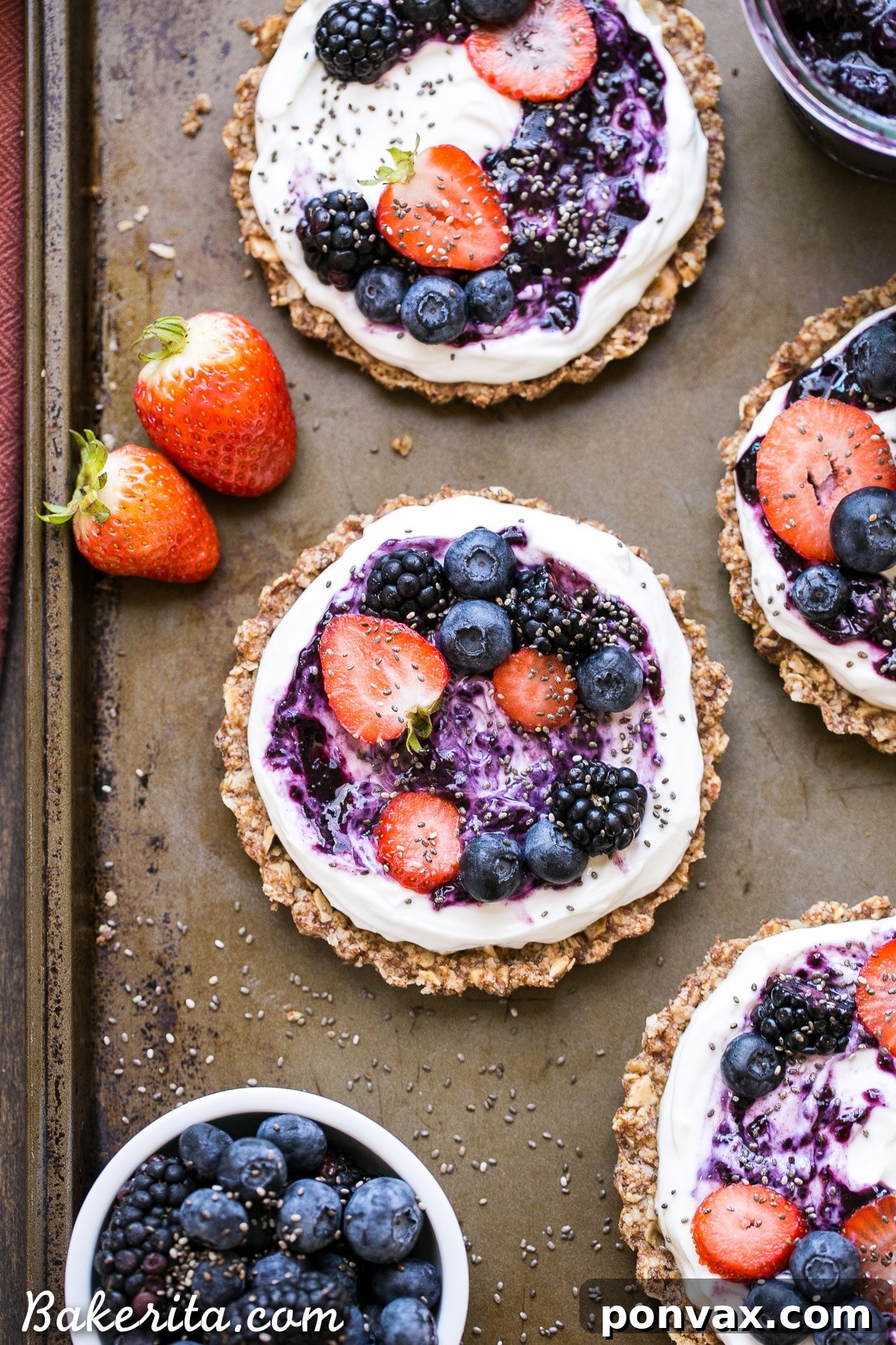 A completed Granola Crust Breakfast Tart, beautifully adorned with Greek yogurt and an array of colorful fresh berries, presented as a healthy and inviting meal.