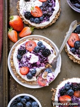 A beautifully plated Granola Crust Breakfast Tart with Greek yogurt and berries, ready to be enjoyed.