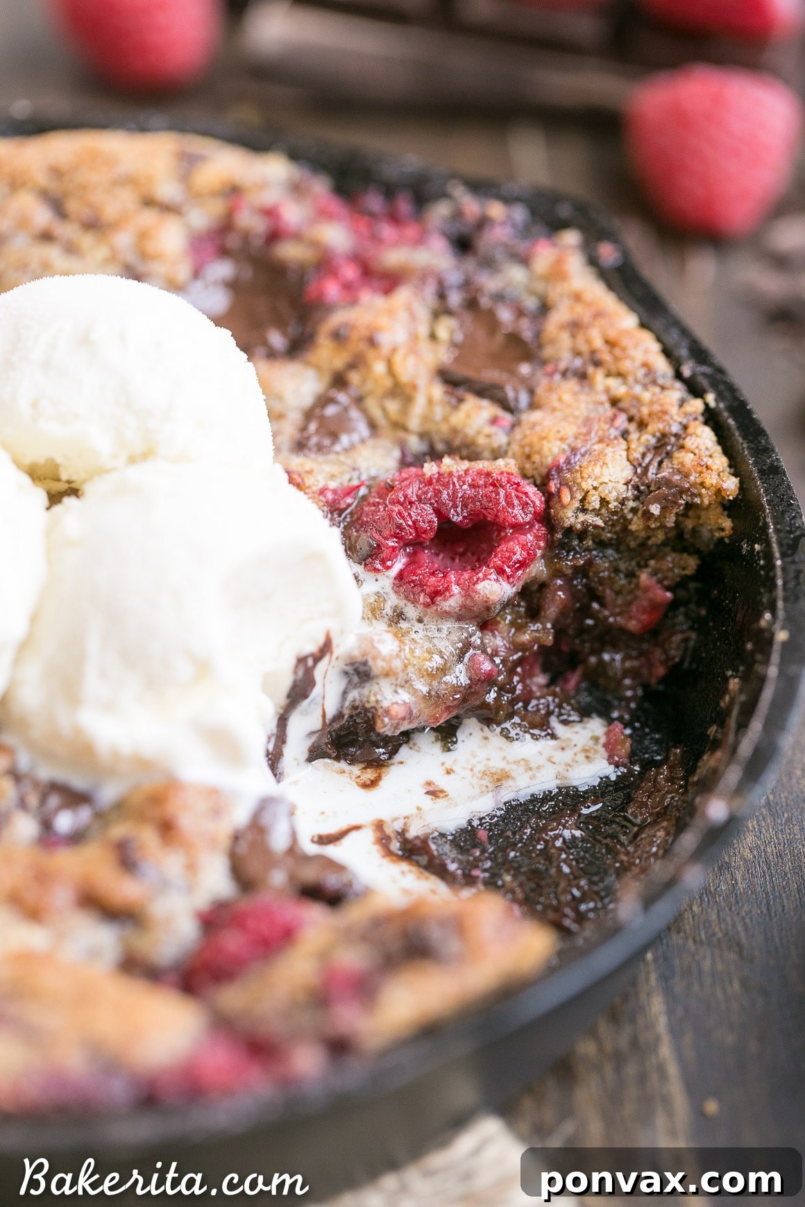 A spoonful of Raspberry Chocolate Chunk Skillet Cookie, demonstrating the ideal gooey texture and rich dark chocolate.