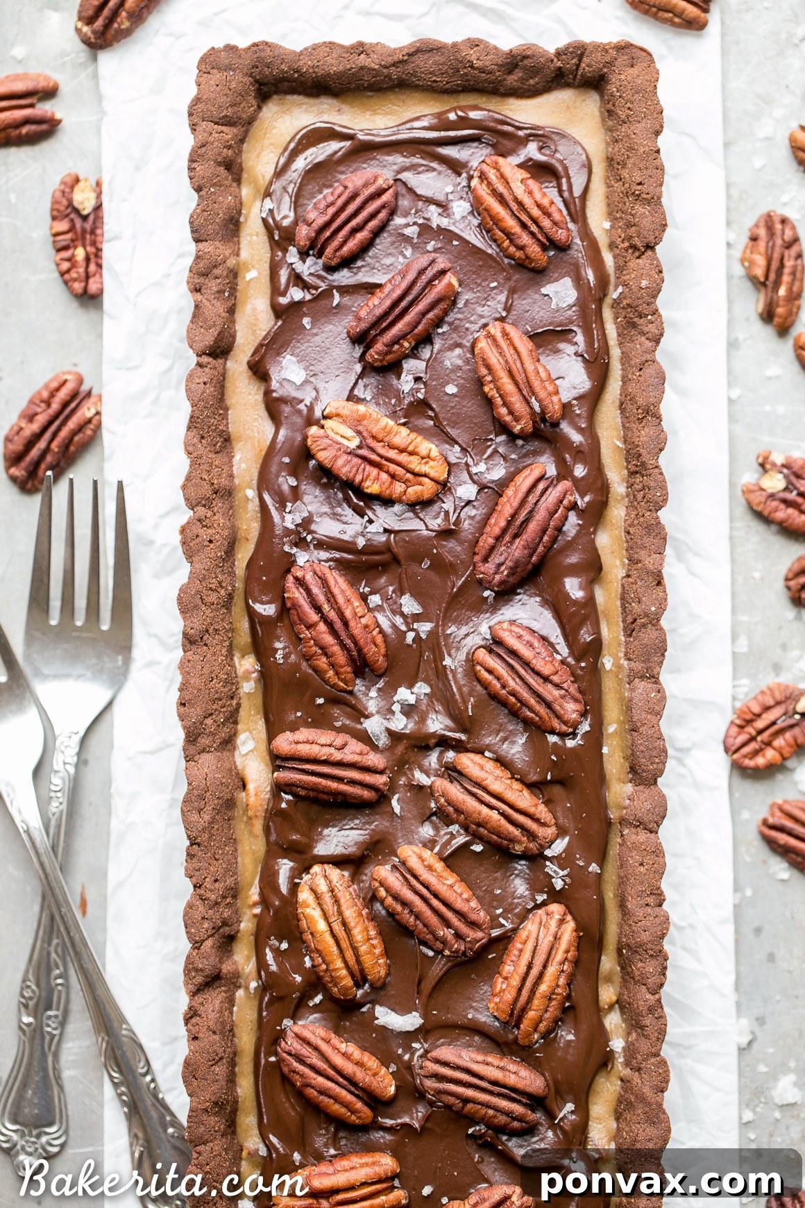 Indulgent Paleo Vegan Gluten Free Chocolate Pecan Tart 2 A beautifully presented Chocolate Pecan Tart, highlighting its rich chocolate shortbread crust, gooey pecan filling, and generous dark chocolate ganache, all topped with whole pecans and flaky sea salt. This tart is gluten-free, Paleo, refined sugar free, and vegan.