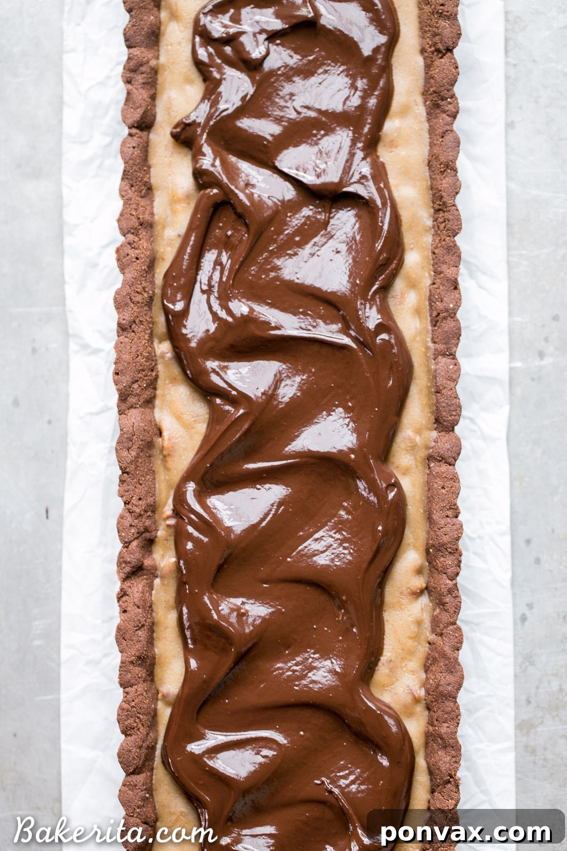 Indulgent Paleo Vegan Gluten Free Chocolate Pecan Tart 3 Detailed shot of the unbaked chocolate shortbread crust being pressed into a tart pan, showcasing its smooth and pliable texture. This gluten-free crust is made with coconut flour for a perfect shortbread feel.