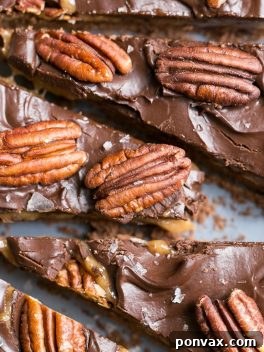 A delicious slice of Chocolate Pecan Tart on a plate, showcasing its layers, with a full tart visible in the background. This gluten-free, Paleo, and vegan dessert is perfect for any occasion.