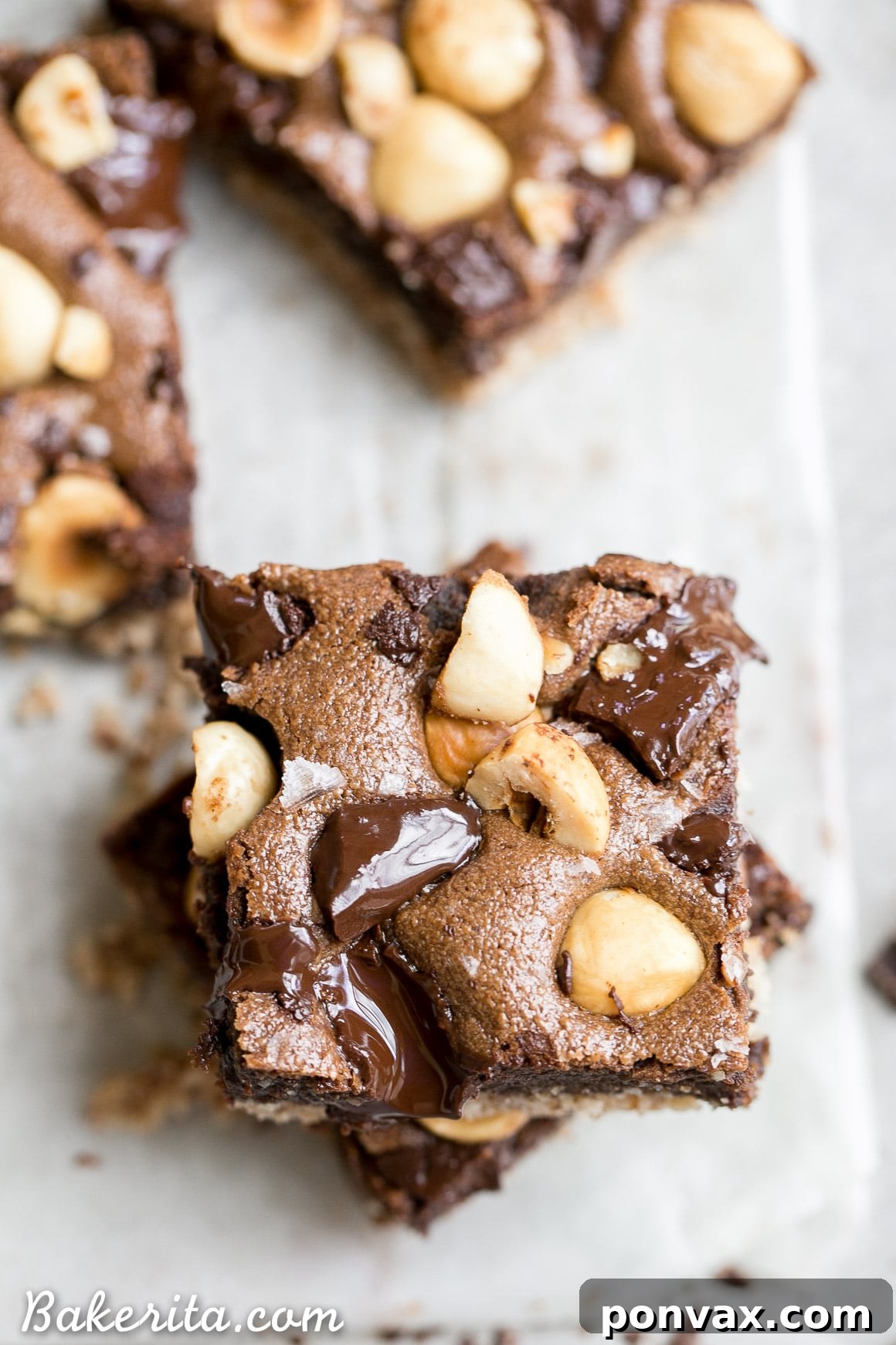 Close-up of a delicious Gluten-Free Chocolate Hazelnut Bar with a hazelnut flour crust, dark chocolate chunks, and whole hazelnuts on top, ready to be enjoyed.