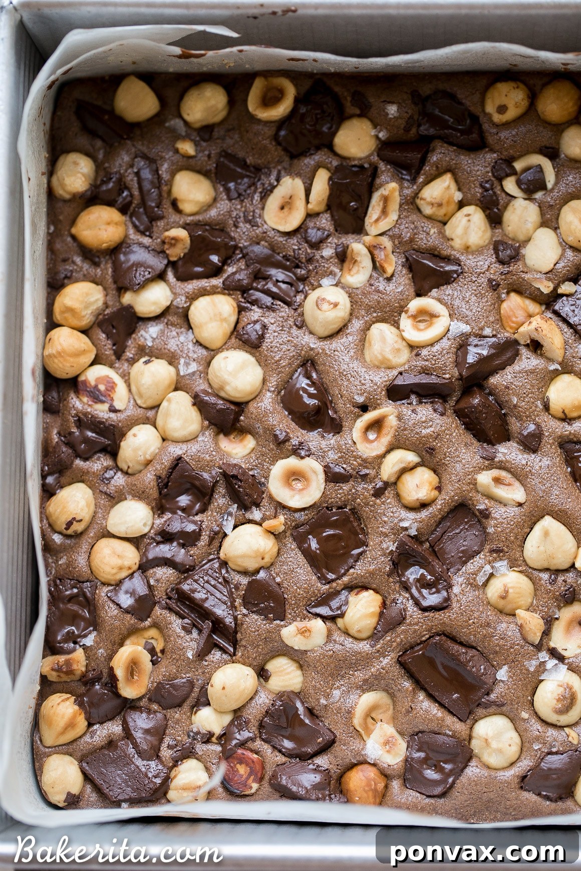 A stack of three freshly baked Chocolate Hazelnut Bars, revealing their rich, fudgy texture and delicious layers of crust and topping.