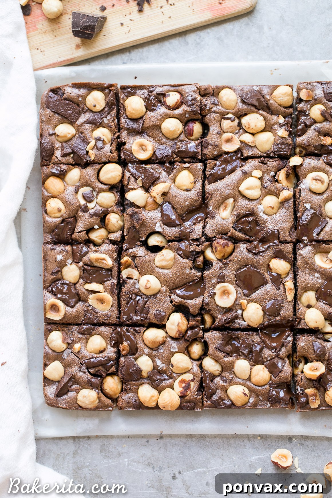 An inviting overhead shot of a baking tray filled with delectable Chocolate Hazelnut Bars, still warm from the oven, garnished with dark chocolate and hazelnuts.