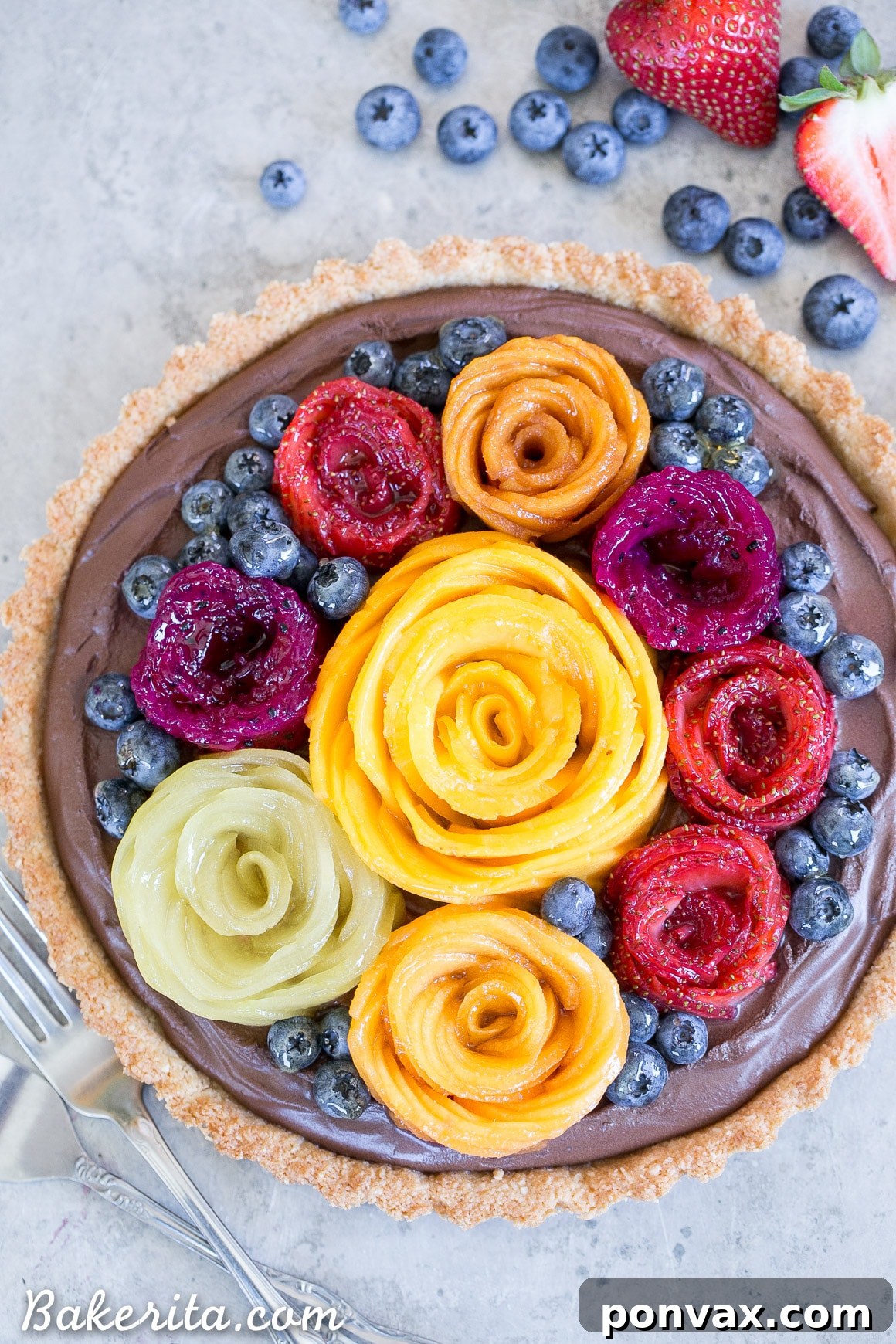 Decadent Vegan Chocolate Mousse Tart with a golden Coconut Crust and fresh, artistic Fruit Flowers. This gluten-free and Paleo dessert is topped with colorful mango, strawberry, and kiwi decorations.