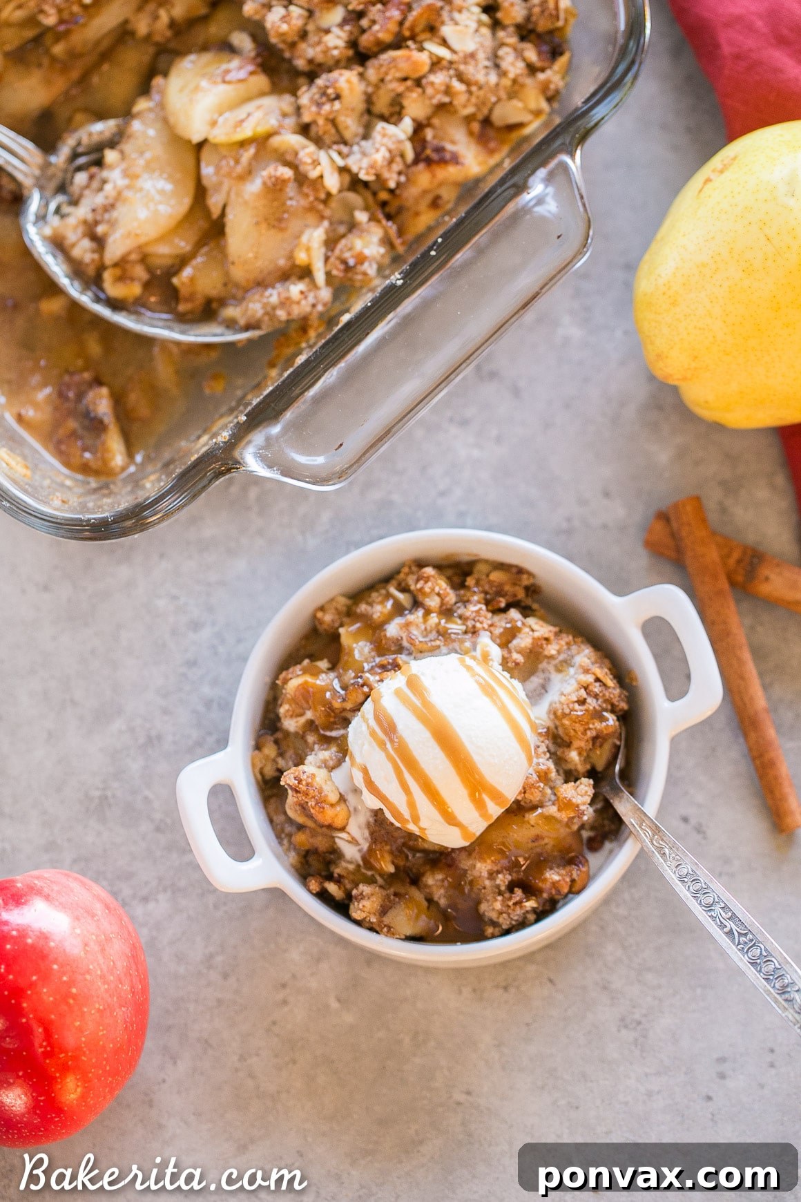 A vibrant, golden-brown Pear Apple Crisp, infused with vanilla, cinnamon, and ginger, sits ready to be served. Its inviting grain-free crumble topping promises a delightful texture, making it a perfect gluten-free, Paleo, and vegan fall dessert.