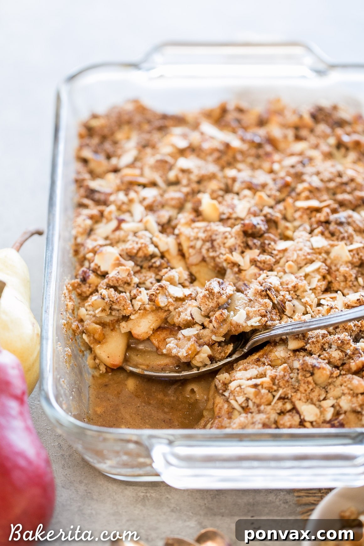 A close-up of a partially eaten Apple Pear Crisp, showcasing the tender fruit filling and golden-brown, textured crumble topping. The inviting warmth and rustic appeal are evident, hinting at the delightful fall flavors within this healthy, grain-free dessert.