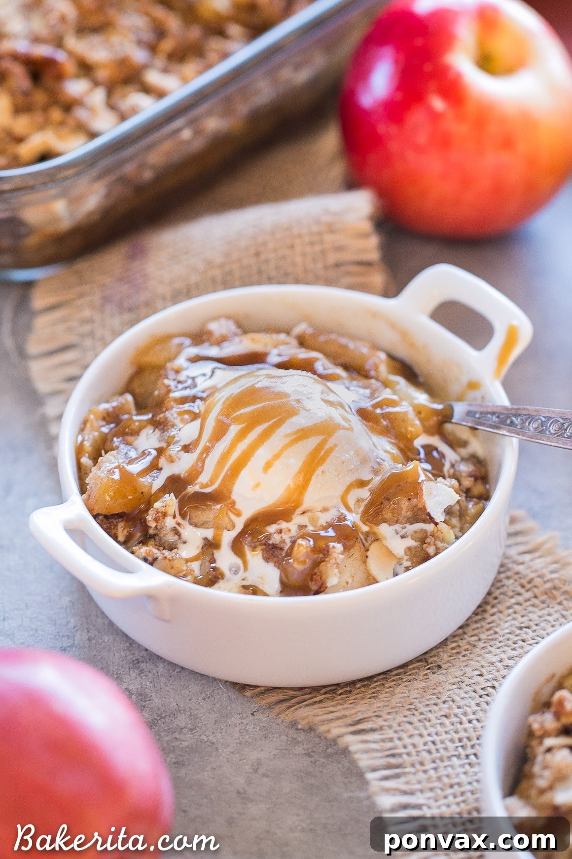 A vibrant close-up of the Apple Pear Crisp filling, featuring a medley of sliced apples and pears tossed with warming spices like cinnamon and ginger, and enriched with vanilla. The fruit glistens with moisture, ready to be baked into a succulent, healthy dessert.