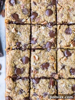 These Pumpkin Oatmeal Scotchie Bars with Chocolate Chips + Pecans are soft, gooey, and absolutely irresistible! These decadent dessert bars couldn't be easier to make.