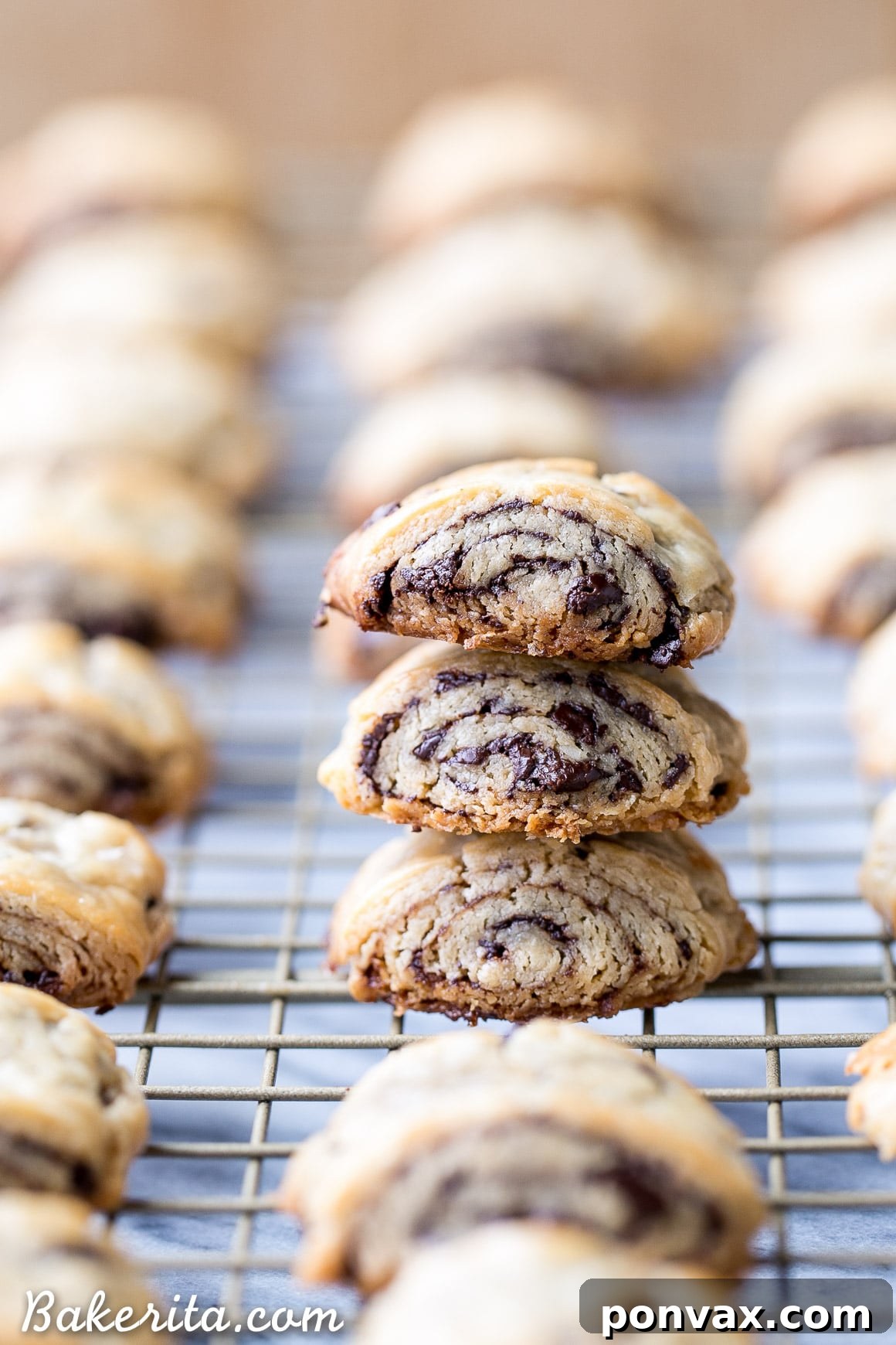 A close-up of baked chocolate rugelach with dark chocolate shavings visible, showcasing the irresistible texture of this gluten-free and refined sugar-free holiday cookie.