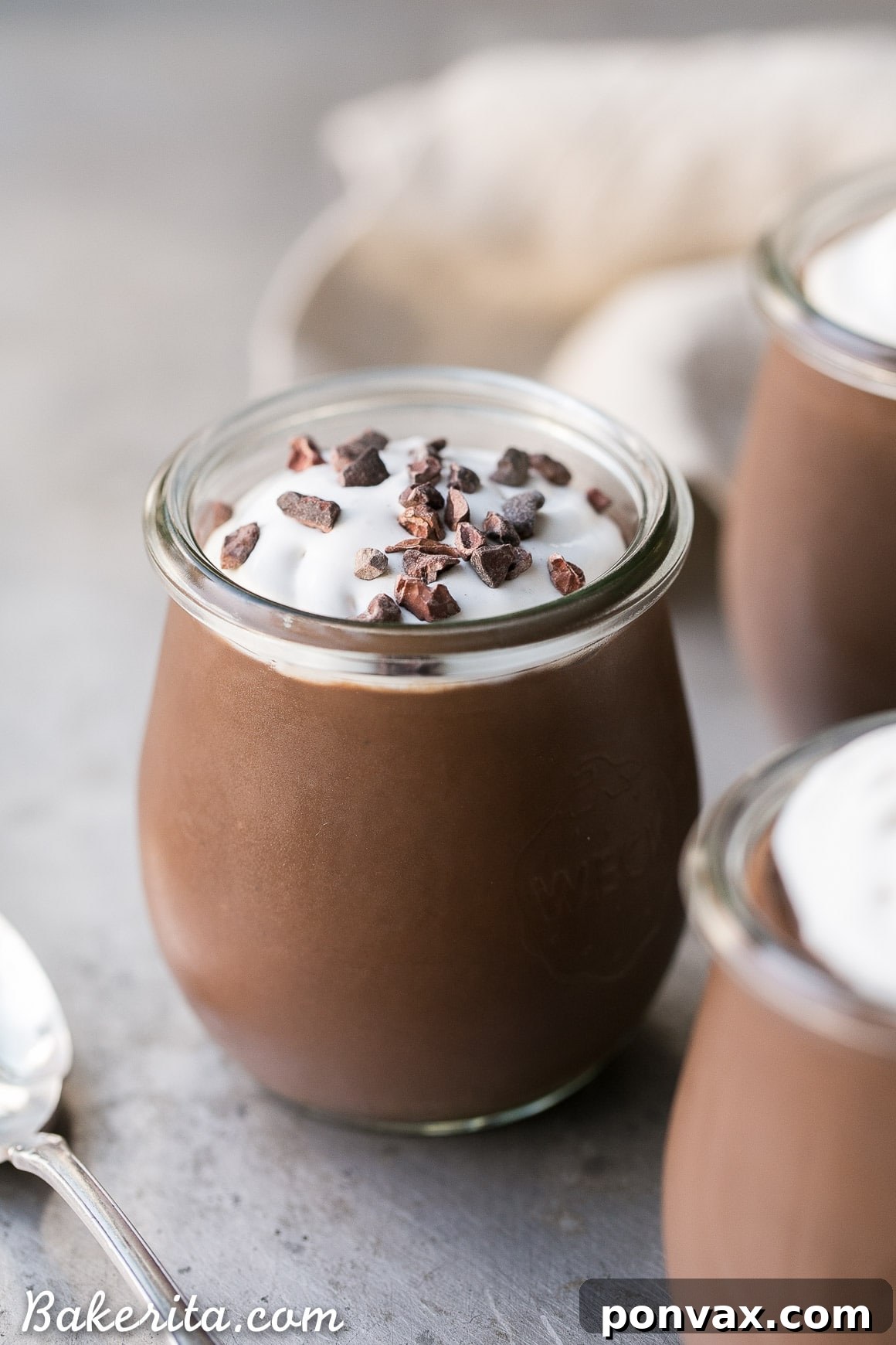 Close-up of the vegan chocolate pudding batter being whisked in a saucepan on the stove, showing its glossy, thickening consistency.