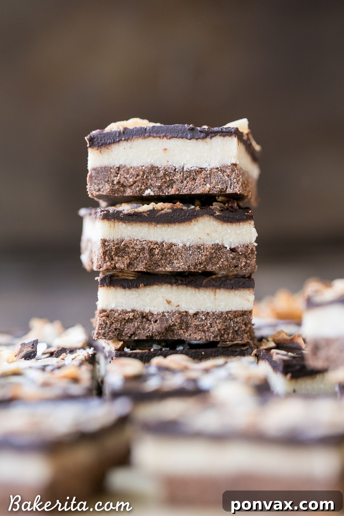Gluten-free, Paleo, and vegan chocolate coconut bars with three layers: chocolate shortbread, creamy coconut filling, and rich chocolate topping.
