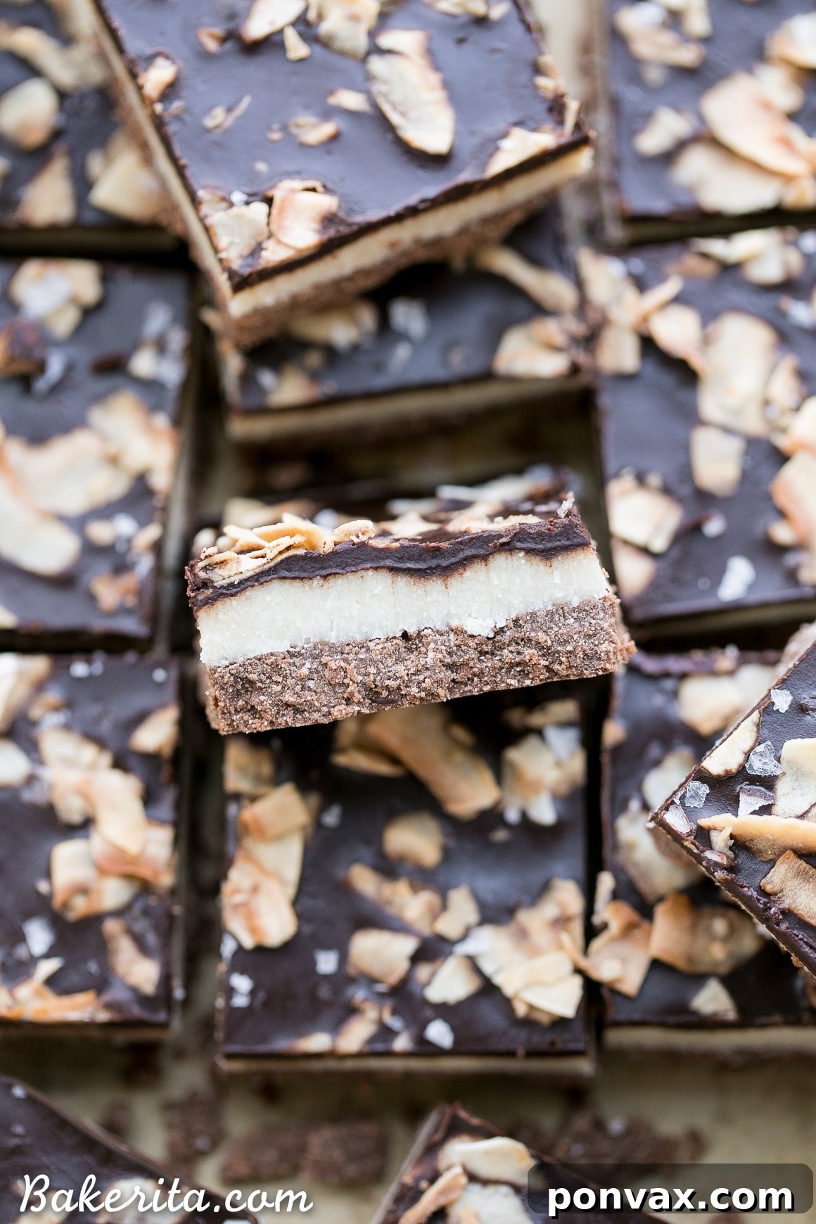 Delicious healthy chocolate coconut bars, featuring a close-up of the three layers and toasted coconut topping.
