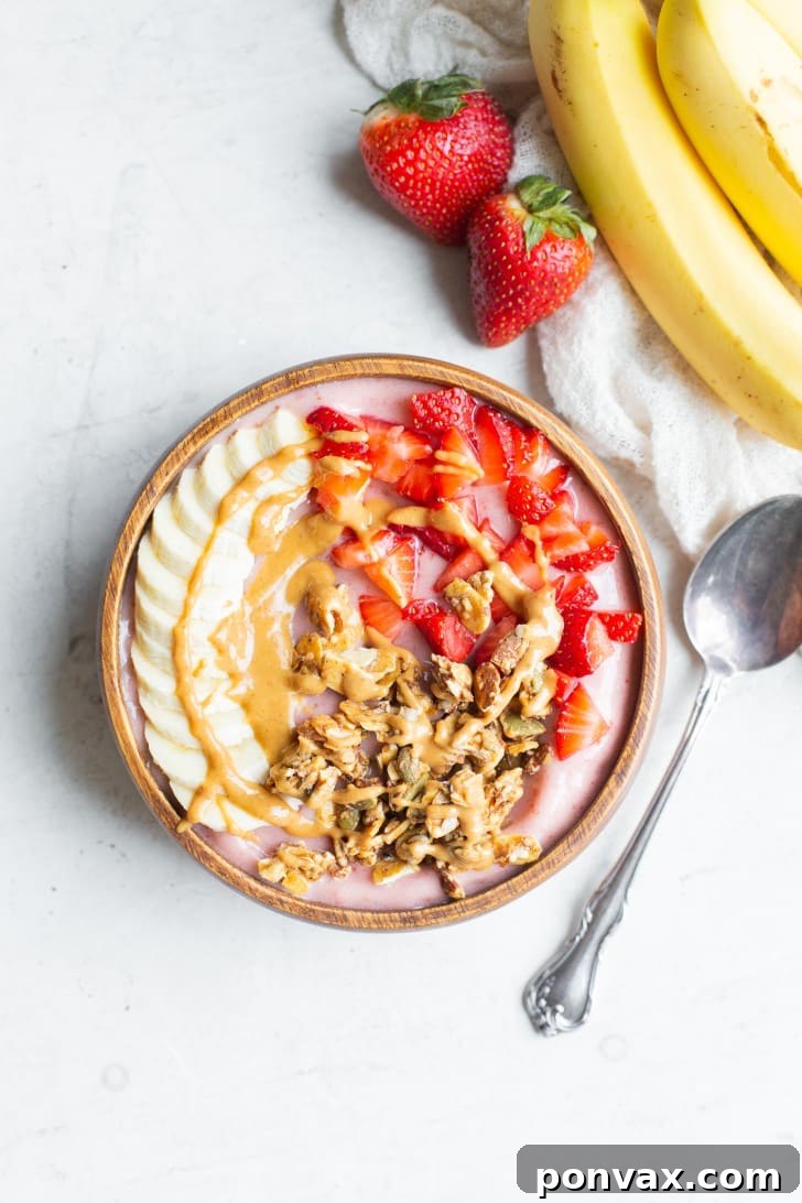 A vibrant Strawberry Banana Smoothie Bowl topped with fresh berries, banana slices, and chia seeds.