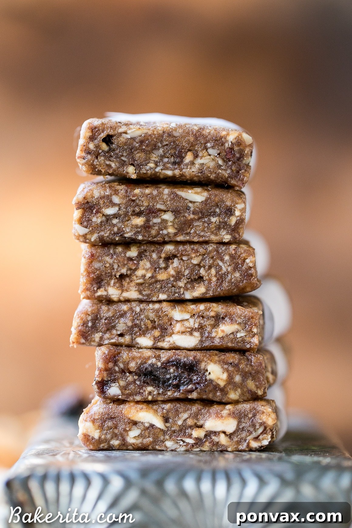 A batch of homemade Apple Pie Larabars being flattened with a rolling pin on parchment paper.