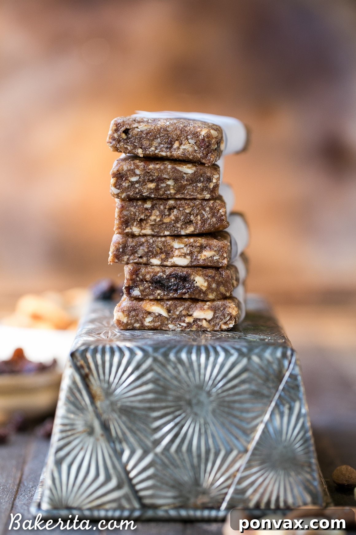 A stack of Homemade Apple Pie Larabars on a wooden board, garnished with a cinnamon stick.