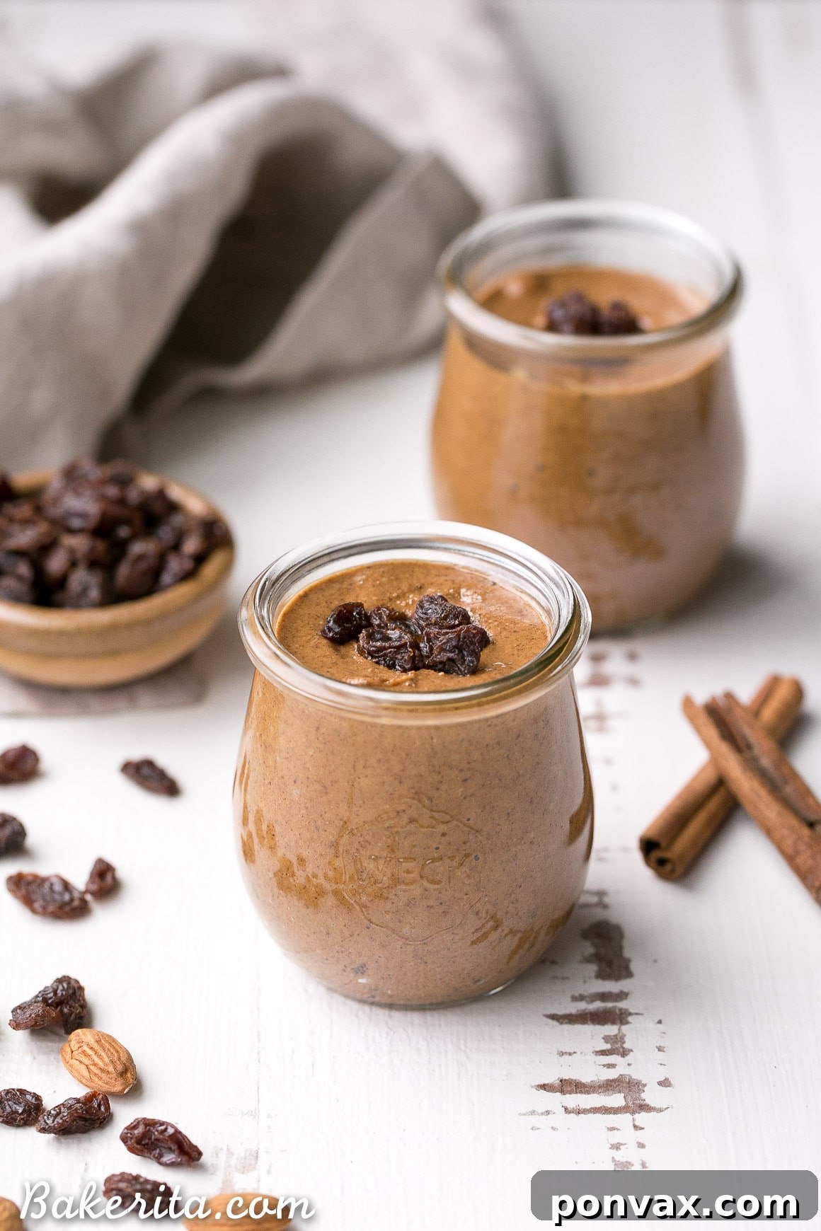 A close-up of Cinnamon Raisin Almond Butter being spread on a slice of toast.