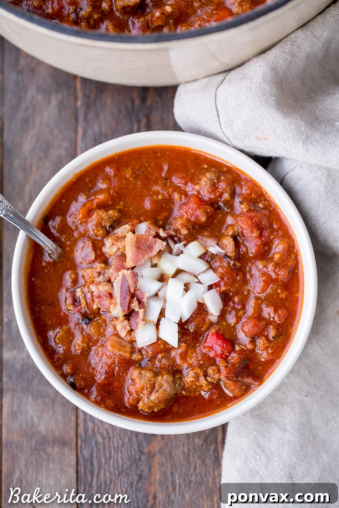 A large pot of Low-Carb Paleo Chili simmering on the stovetop, ready to be served. The surface is rich and bubbly, promising a comforting meal.